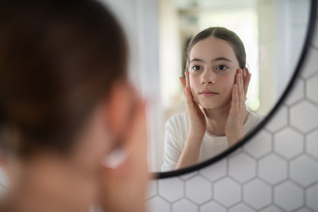 Teenager treating acne, taking care of her skin at home.の写真素材