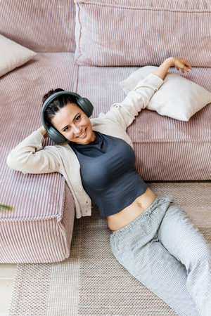 Woman relaxing at home, enjoying music after work.の写真素材