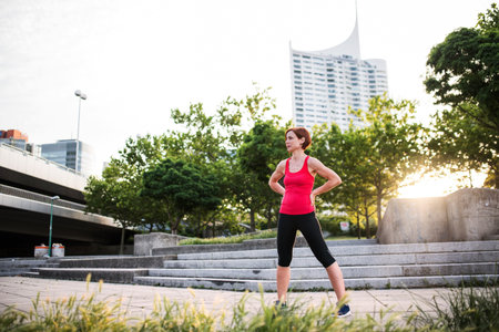 Young woman standing outdoors in city, resting after exercise.の写真素材