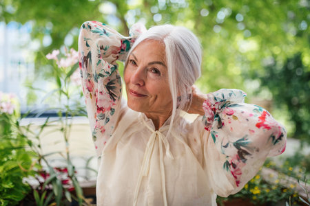 Portrait of beautiful senior woman standing on balcony.