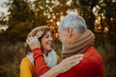 Romantic moment between senior couple, standing in autumn nature.の写真素材
