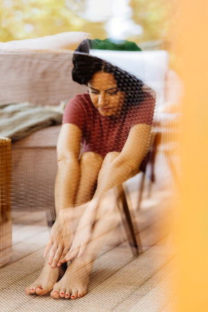 Woman in deep thought behind glass reflection.の写真素材