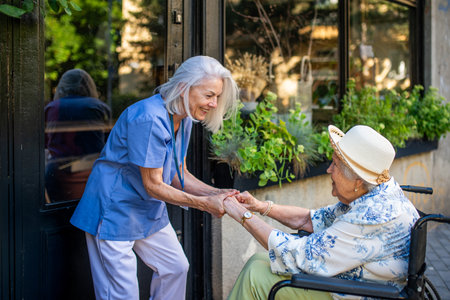 Tender moment between older caregiver and senior female patient in wheelchair.の写真素材