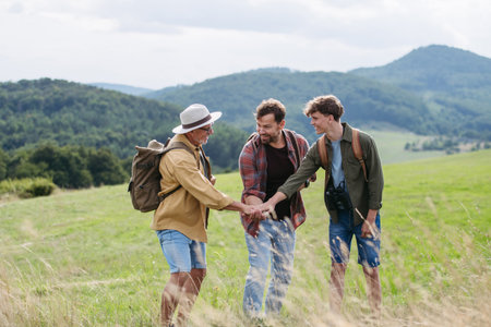 Grandfather, father and teen boy hiking togeter in nature, spending time together during weekend.の写真素材