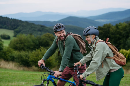 Couple cycling together in nature, smiling and enjoying outdoor adventure.の写真素材