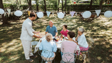 Areal view of grandparents, parents and kids dining together outside.の写真素材