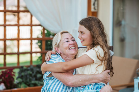 Grandmother and granddaughter hugging in the garden.の写真素材