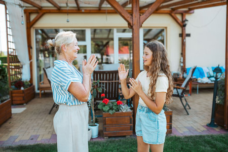 Grandmother and granddaughter playing clapping game.の写真素材