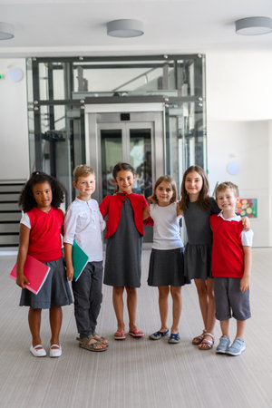 Group of schoolkids in uniforms, standing in school corridor.の写真素材