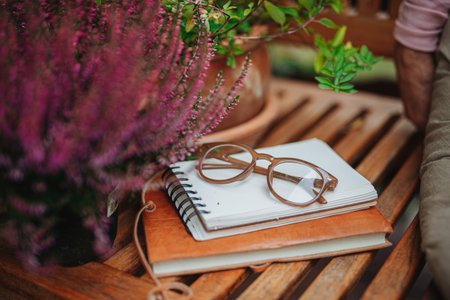 Reading glasses resting on notebook in autumn gardenの写真素材