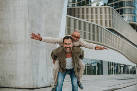 Adult son carrying older father on his back.