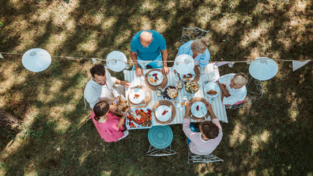 Top view of grandparents, parents and kids during grill party.