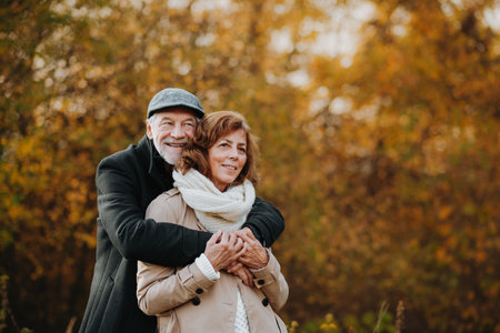 Older couple spending time outdoors in fall season.の写真素材
