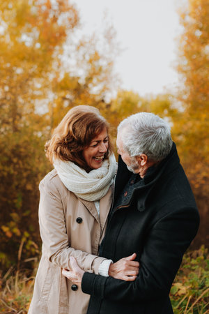 Romantic walk through fall forest by senior couple.の写真素材