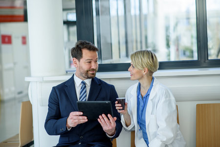 Pharmaceutical sales representative introducing new medication to female doctor.