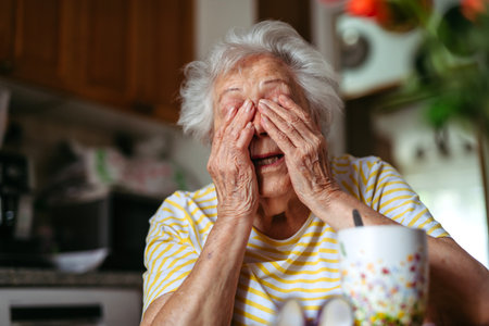 Portrait of worried senior woman in kitchen.