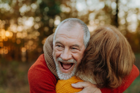 Portrait of senior man hugging his wife in autumn nature.