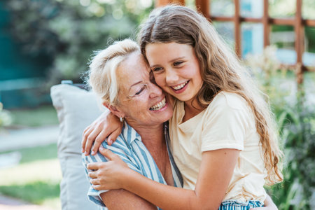 Grandmother and granddaughter hugging in the garden.の写真素材