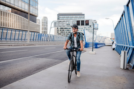 City commuter riding bike on street, wearing backpack.
