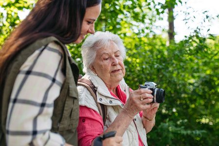 Elderly mother and daughter photograhing wildlife during forest walk.の写真素材