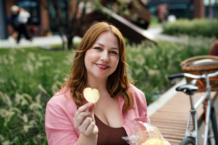 Plus size woman holding potato chip.の写真素材