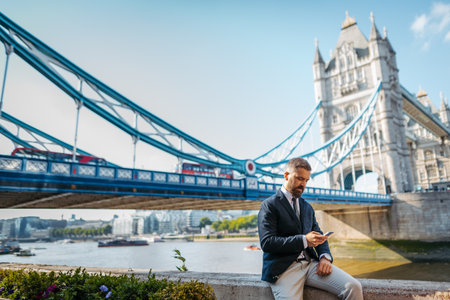 Businessman looking at smartphone, waiting for someone.の写真素材