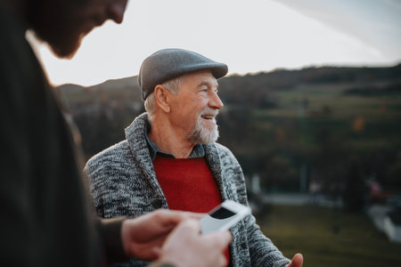 Man showing older person something in smartphone.の写真素材