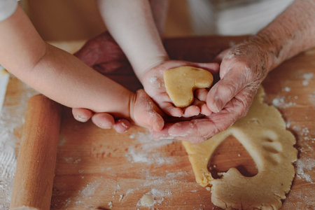Hands of old woman and kid preparing homemade cookies.の写真素材