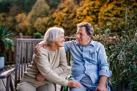 Peaceful moment for senior couple, enjoying warm autumn evening on terrace.の写真素材