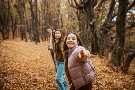 Multigenerational family portrait. Parents, grandma and daughters on walk in forest.の写真素材