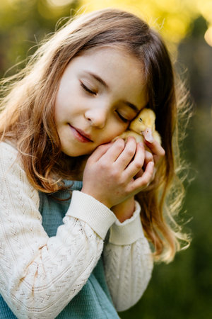 Lovely girl cuddling baby duckling.の写真素材