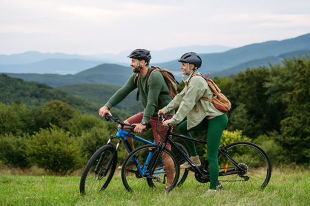 Couple cycling together in nature, smiling and enjoying outdoor adventure.の写真素材