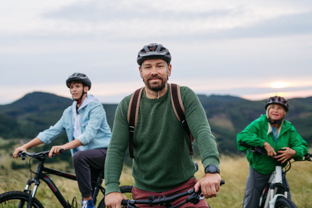 Potrait of handsome dad during family biking adventure in nature. Cycling trip during autumn day.の写真素材