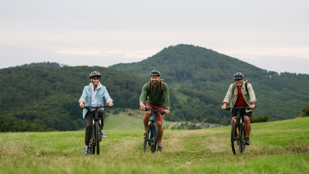 Grandfather, father and teen boy on cycling trip in nature.の写真素材