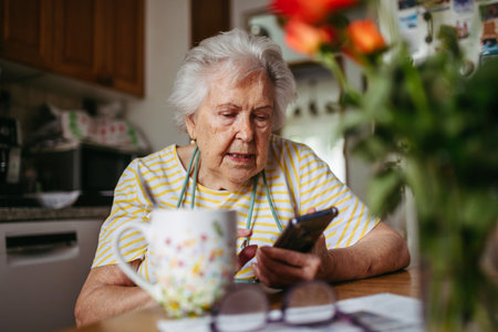 Portrait of senior woman holding smartphone at home.