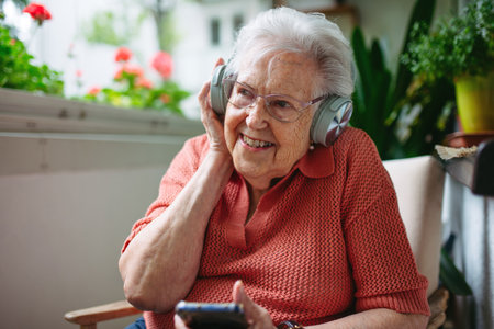 Portrait of senior woman listening podcats from smartphone.
