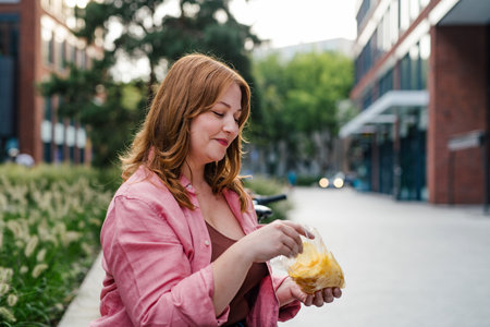 Plus size woman holding potato chip.の写真素材