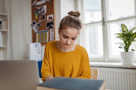 Young female student sitting at the table and studying.の写真素材