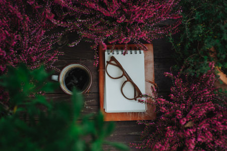 Reading glasses resting on notebook in autumn garden