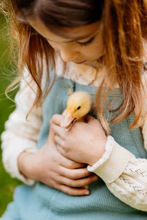 Lovely girl cuddling baby duckling.の写真素材