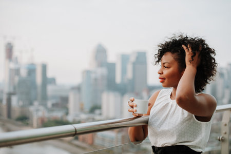 Portrait of a businesswoman drinking coffee on terrace of modern office.