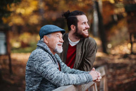 Senior father and his son walking in nature, talking.の写真素材