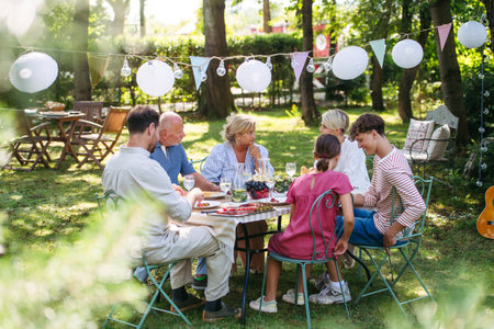 Family sharing food during garden grill party.の写真素材