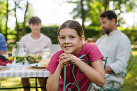Potrait of cute girl during family gathering in summer garden.の写真素材