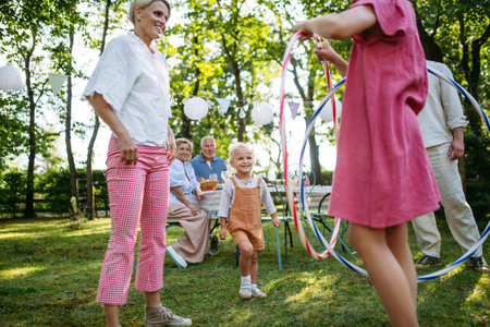 Family enjoying outdoor summer gathering with playful activities.の写真素材