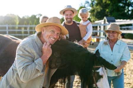 Farmer family standing in horse paddock with pony.の写真素材