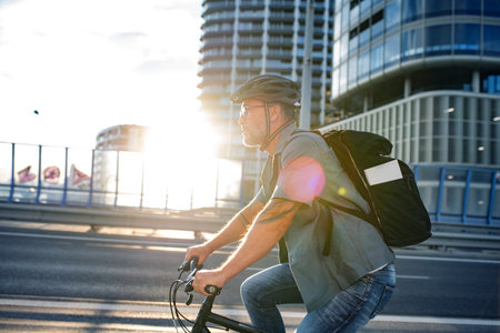 Male cyclist riding bike down the street.の写真素材