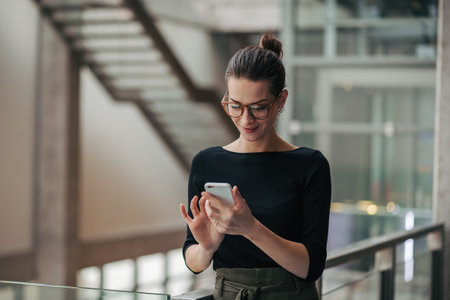 Portrait of young businesswoman reading email on smartphone.の写真素材