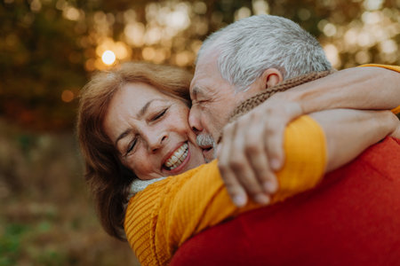 Romantic moment between senior couple, standing in autumn nature.の写真素材