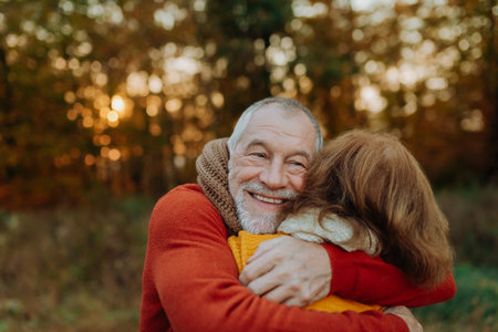 Romantic moment between senior couple, standing in autumn nature.の写真素材